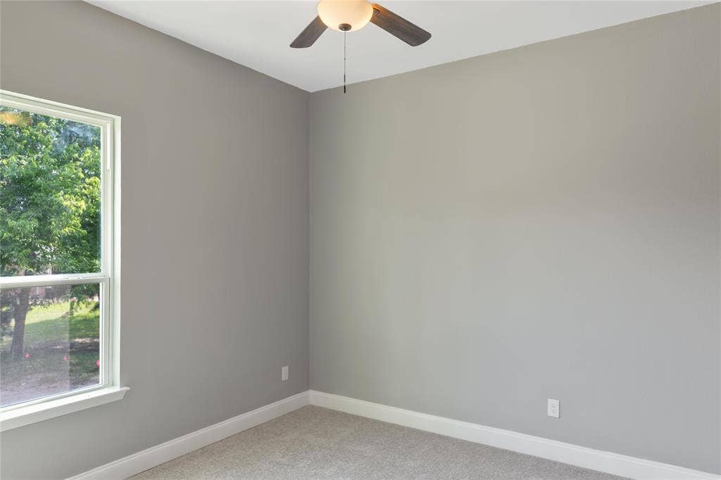 10560 Lago Vista, Quinlan, TX 75474 Spare room with carpet floors and a ceiling fan