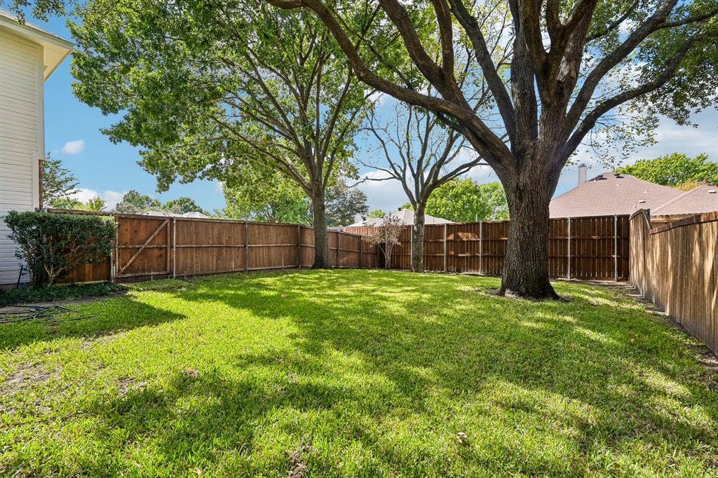 758 Livingston Drive, Allen, TX 75002 Backyard featuring a grass lawn, wood privacy fencing, and mature hardwood trees