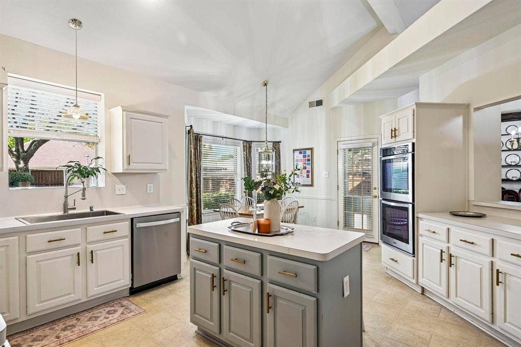 758 Livingston Drive, Allen, TX 75002 Kitchen featuring a center island, vaulted ceiling, stainless steel double wall oven, neutral-toned cabinetry, and tile flooring