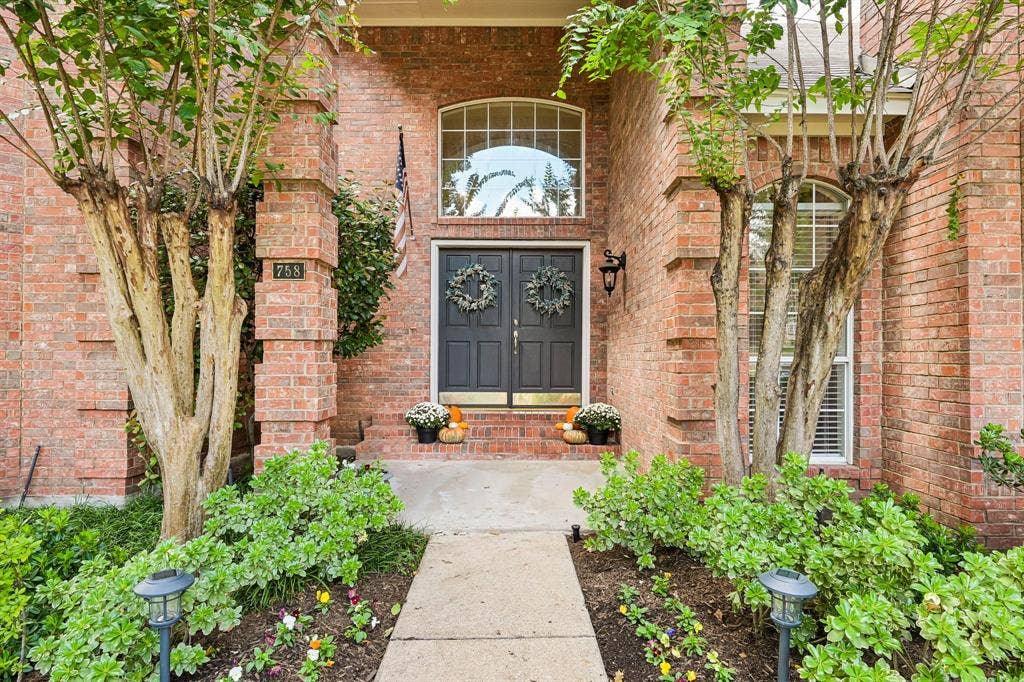 758 Livingston Drive, Allen, TX 75002 Traditional brick facade entry featuring double doors with a transom window, concrete walkway, and mature landscaping