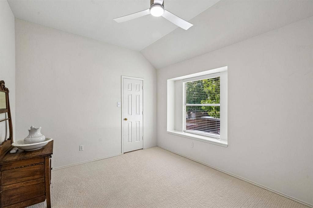 758 Livingston Drive, Allen, TX 75002 Room featuring a vaulted ceiling, recessed window with a ledge, carpeting, a modern ceiling fan with integrated lighting, and a six-panel interior door