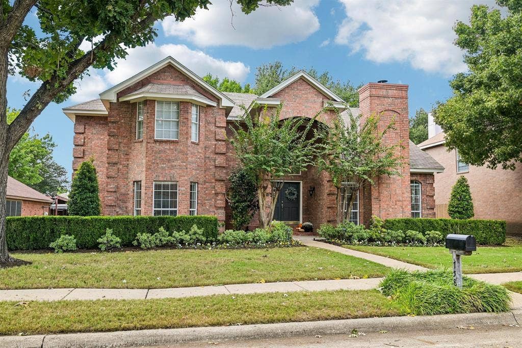758 Livingston Drive, Allen, TX 75002 Traditional brick exterior featuring stone quoins, a multi-gabled roofline, an arched covered entryway, and a chimney stack