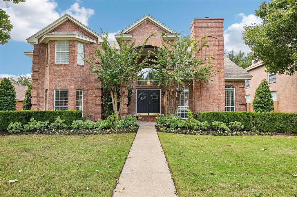758 Livingston Drive, Allen, TX 75002 Two-story brick exterior featuring a prominent chimney, multi-gabled roofline, double front entry doors, and arched window detailing