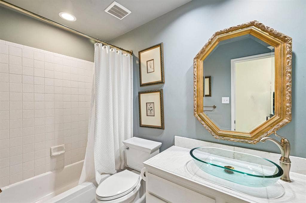 758 Livingston Drive, Allen, TX 75002 Bathroom featuring a white vanity with a stone countertop, an oval glass vessel sink, a metallic faucet, and an octagonal wall mirror
