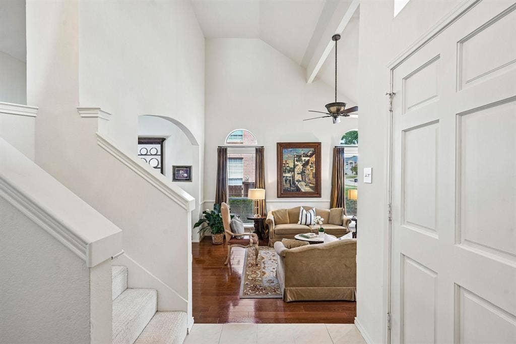 758 Livingston Drive, Allen, TX 75002 Vaulted ceilings, wood-finish flooring, staircase with carpeted steps, arched architectural detailing, and recessed windows