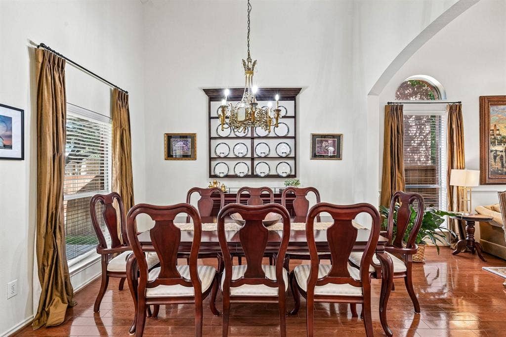 758 Livingston Drive, Allen, TX 75002 Formal dining area featuring high ceilings, wood-finish flooring, a decorative arched window, a built-in display shelf, and an ornate metal chandelier
