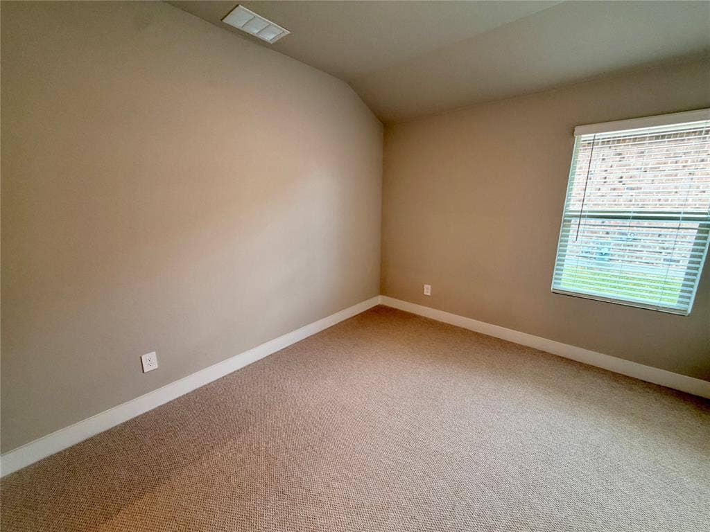 Neutral-toned room featuring high vaulted ceilings, wall-to-wall carpeting, and a single-pane window with horizontal blinds