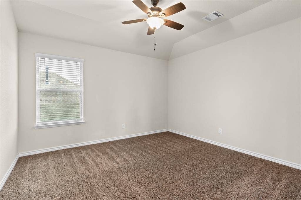 5751 Mountain Hollow Drive, Dallas, TX 75249 Interior space featuring vaulted ceilings, neutral wall tones, textured carpeting, and a ceiling fan with integrated lighting