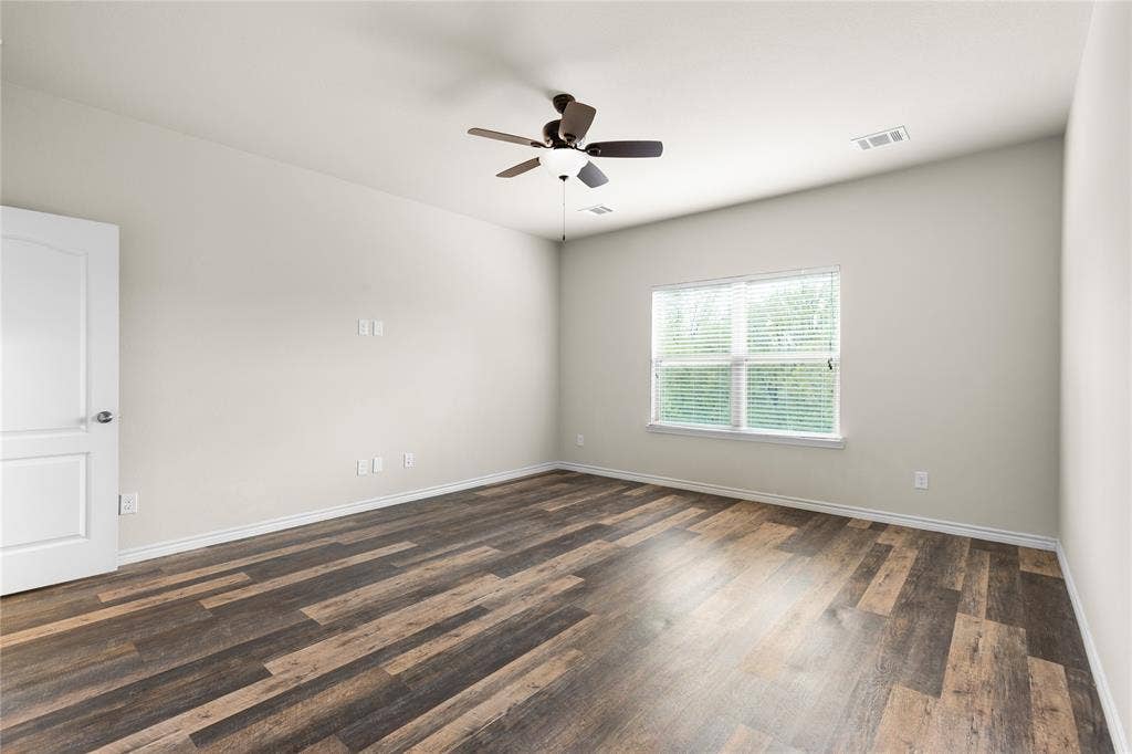 5751 Mountain Hollow Drive, Dallas, TX 75249 Wood-finish flooring, neutral wall tones, multi-pane window, and ceiling fan with integrated lighting