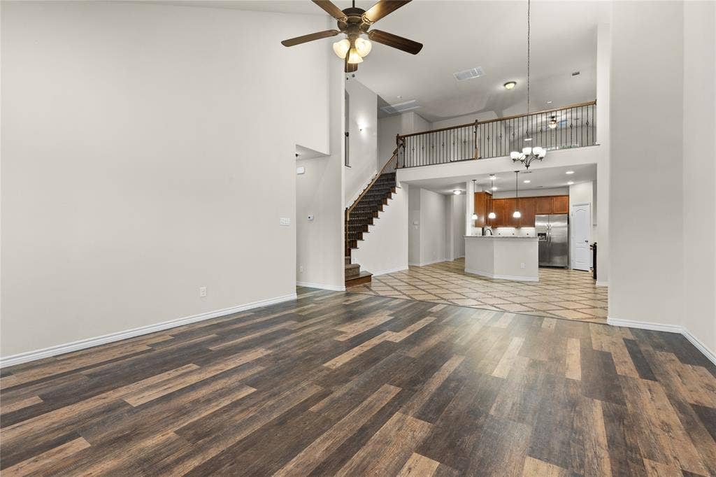 5751 Mountain Hollow Drive, Dallas, TX 75249 Vaulted ceilings, wood-finish flooring, built-in staircase with metal balusters, and a mezzanine overlook with iron railing