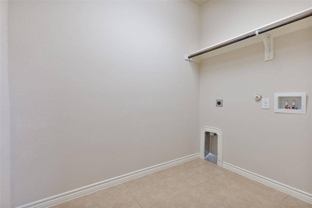 5751 Mountain Hollow Drive, Dallas, TX 75249 Dedicated utility space featuring tile flooring, neutral wall finishes, integrated shelving, and dedicated plumbing connections