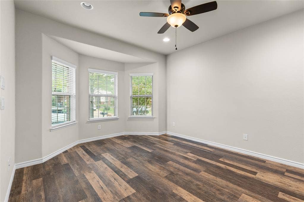 5751 Mountain Hollow Drive, Dallas, TX 75249 Bay window featuring multi-pane glass, wood-finish flooring, ceiling fan with integrated lighting, and neutral wall tones