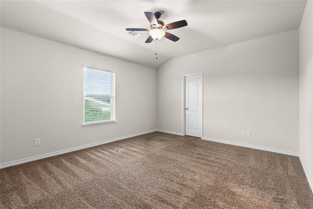 5751 Mountain Hollow Drive, Dallas, TX 75249 Neutral-toned room featuring vaulted ceilings, carpeting, a ceiling fan with integrated lighting, and a single-panel interior door