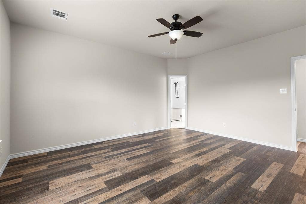 5751 Mountain Hollow Drive, Dallas, TX 75249 Spacious room featuring wood-finish flooring, neutral wall paint, and a ceiling-mounted fan with integrated lighting