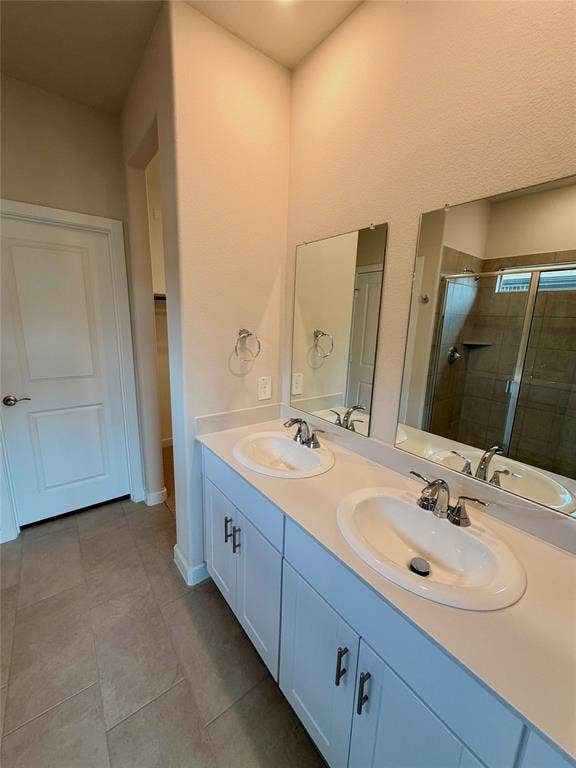 Dual-sink vanity with white cabinetry, solid-surface countertop, chrome fixtures, and twin rectangular mirrors