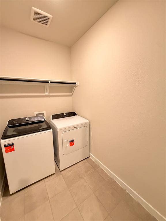 Utility space featuring neutral tile flooring, light-toned wall finish, and a wall-mounted shelving unit