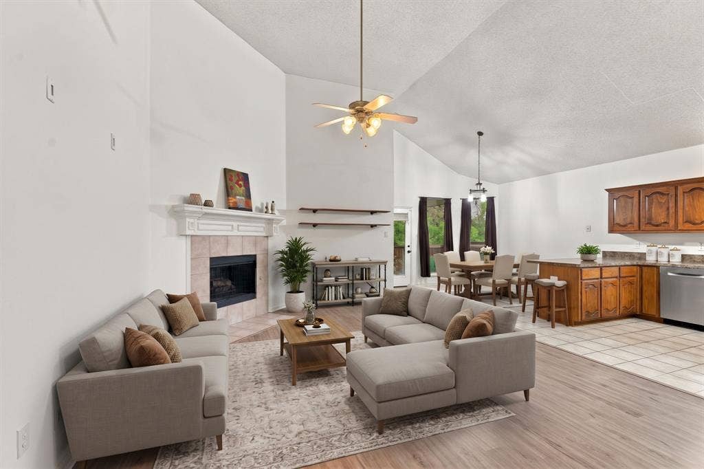 The recently painted, wide open living space flows directly into the kitchen and dining area.  High ceilings and fireplace make this area ideal for entertaining or relaxing.  virtually staged.