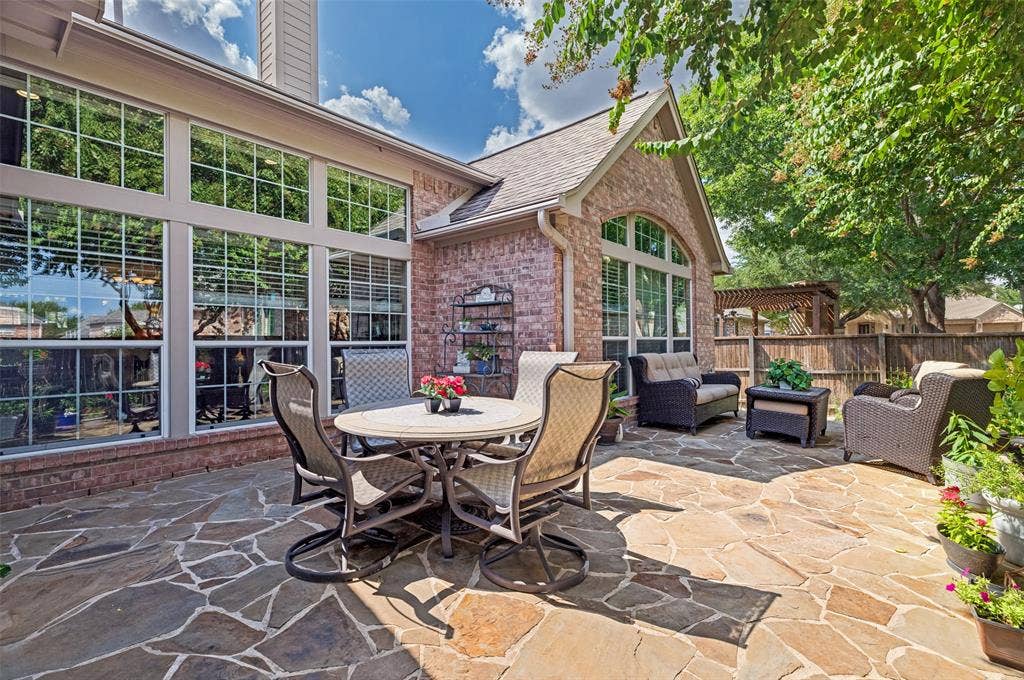 604 Barkley Drive, McKinney, TX 75071 Flagstone patio with brick exterior walls, large grid-pattern windows, and arched window detailing