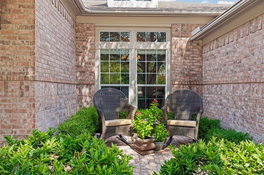 604 Barkley Drive, McKinney, TX 75071 Brick exterior featuring a recessed entryway, multi-pane windows, and a paved patio surface