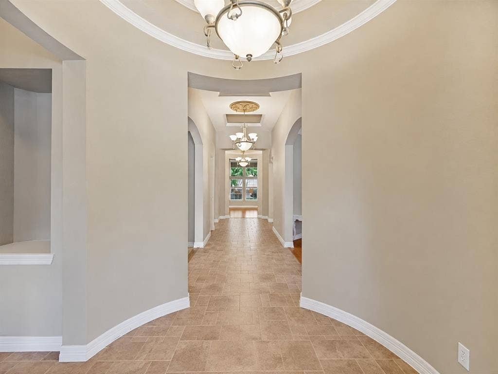 604 Barkley Drive, McKinney, TX 75071 Foyer featuring a circular tray ceiling with crown molding, custom ceiling medallions, arched architectural openings, built-in display niche, and large-format tile flooring