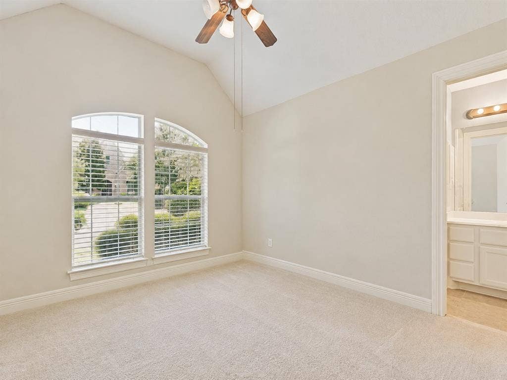 604 Barkley Drive, McKinney, TX 75071 Bright, airy bedroom showcasing soaring vaulted ceilings with ceiling fan, abundant natural light from dual arched windows with plantation shutters, neutral carpet flooring, and generous square footage ideal for flexible furnishing arrangements
