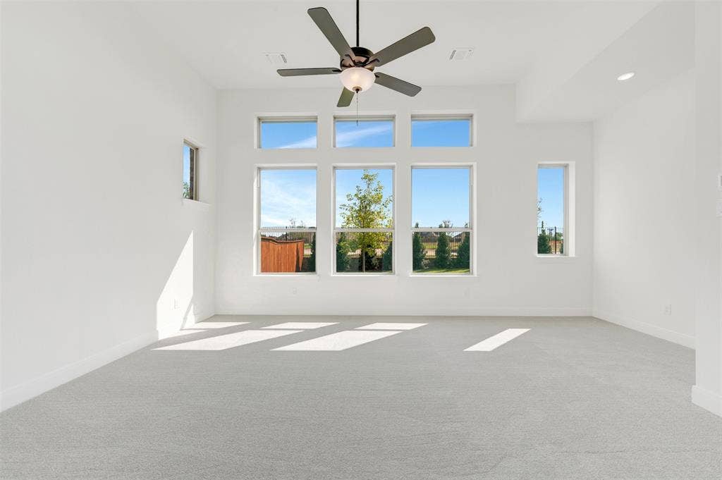 3469 Jersey Drive, Midlothian, TX 76065 High ceilings with a central ceiling fan, neutral carpeting, and a series of large windows featuring natural light
