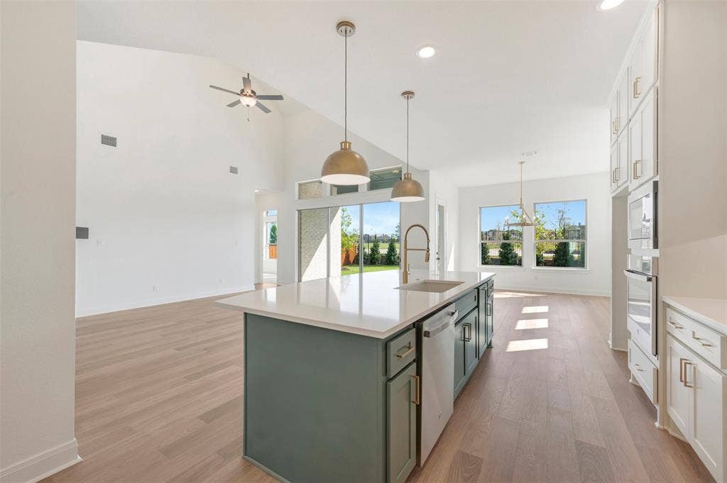 3469 Jersey Drive, Midlothian, TX 76065 Kitchen featuring a central island with a quartz countertop, wood-finish flooring, vaulted ceilings, pendant lighting, and built-in wall oven cabinetry