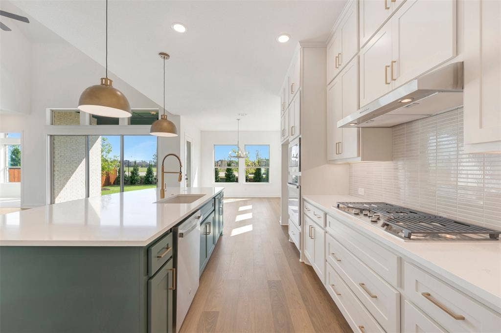 3469 Jersey Drive, Midlothian, TX 76065 Kitchen featuring floor-to-ceiling cabinetry, a central island with a contrasting base, solid-surface countertops, horizontal tile backsplash, and wood-finish flooring