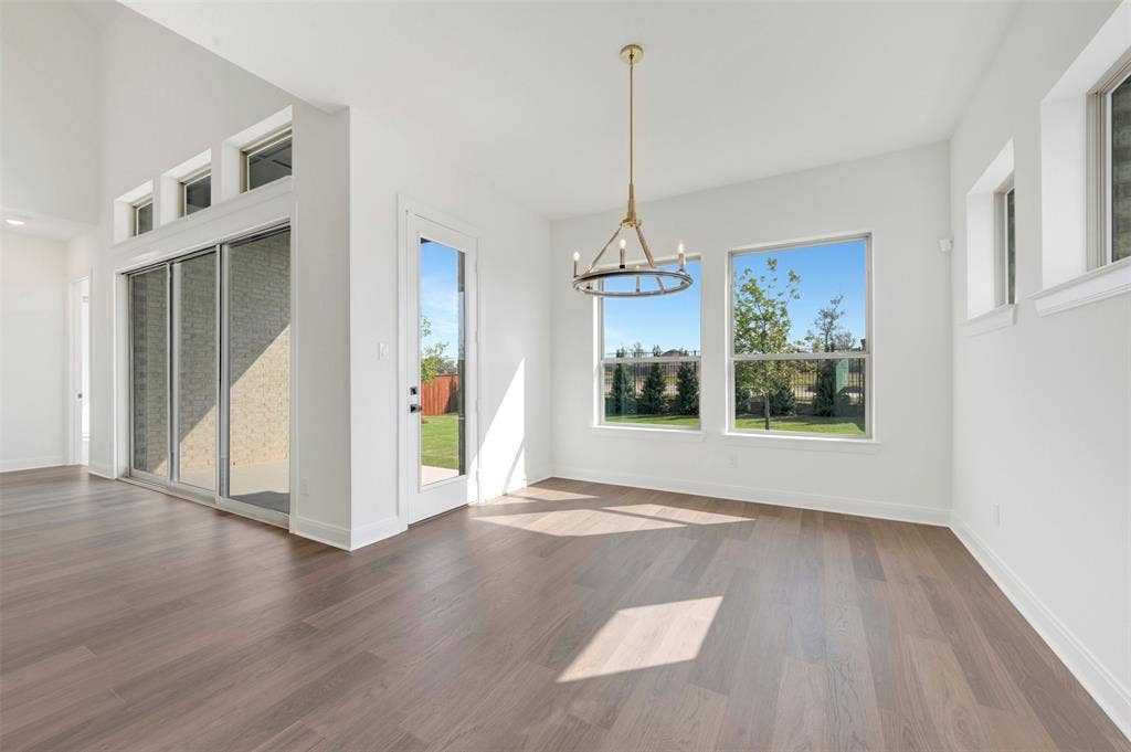 3469 Jersey Drive, Midlothian, TX 76065 Vaulted ceilings, wood-finish flooring, sliding glass door, multi-light metal chandelier, and large windows