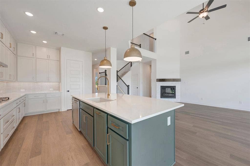 3469 Jersey Drive, Midlothian, TX 76065 Kitchen featuring a center island with a stone-finish countertop and brass-tone hardware, shaker-style cabinetry, recessed lighting, dual pendant lights, and wood-finish flooring