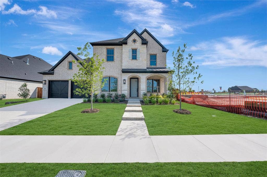 3469 Jersey Drive, Midlothian, TX 76065 Two-story brick exterior featuring a multi-gabled roofline, dark-framed multi-pane windows, a recessed covered entryway, and an attached two-car garage with carriage-style doors