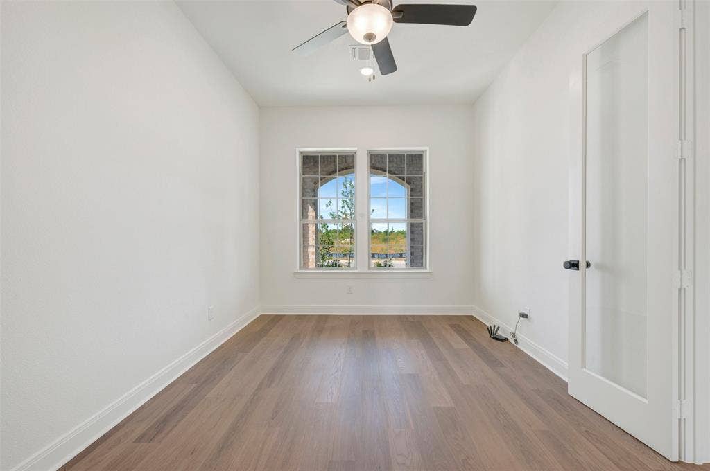 3469 Jersey Drive, Midlothian, TX 76065 Wood-finish flooring, dual windows with arched brick surround, and a ceiling-mounted light fixture with fan