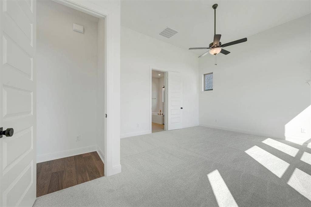 3469 Jersey Drive, Midlothian, TX 76065 High-ceiling interior featuring carpeted flooring, a multi-paneled door, a dark-finish ceiling fan with integrated lighting, and a square window