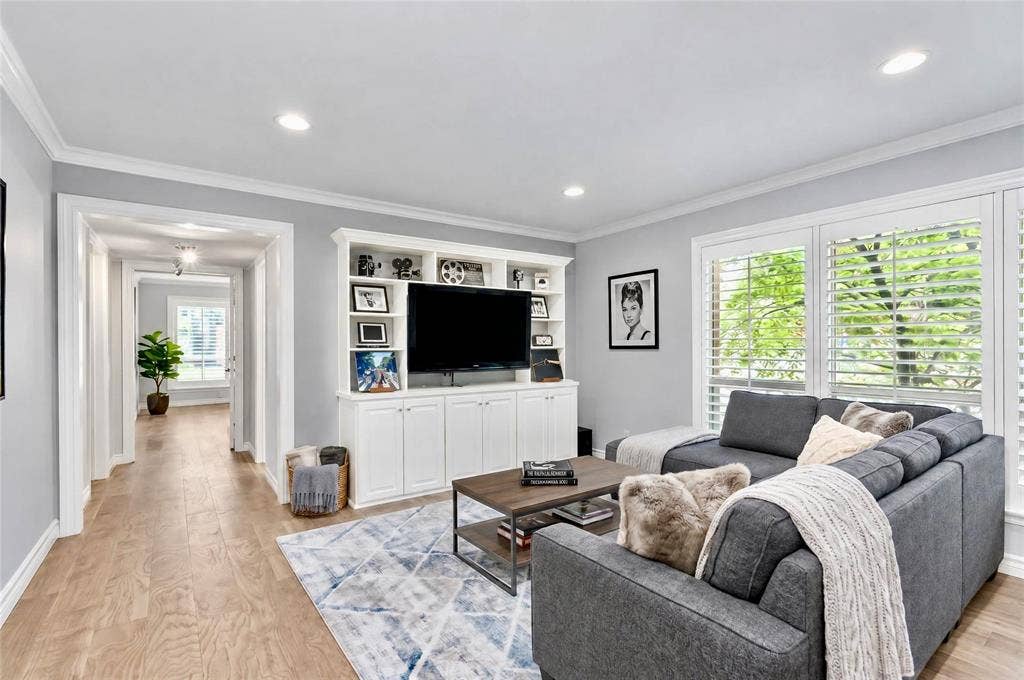 8629 Edgemere Road, #13, Dallas, TX 75225 Living space featuring wood-finish flooring, recessed lighting, crown molding, built-in cabinetry, and white louvered window shutters
