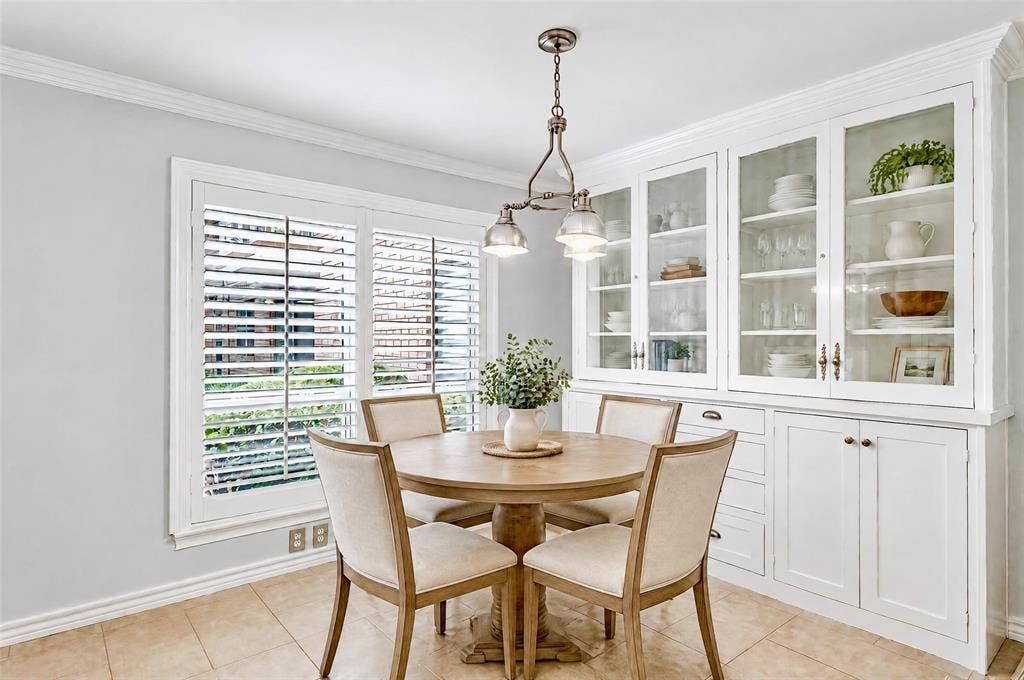 8629 Edgemere Road, #13, Dallas, TX 75225 Built-in cabinetry with glass-front display doors, crown molding, tile flooring, and plantation shutters