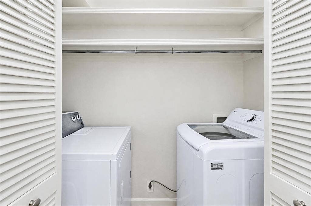 8629 Edgemere Road, #13, Dallas, TX 75225 Laundry closet featuring louvered bi-fold doors, dual built-in overhead storage shelves, and a metal garment rod