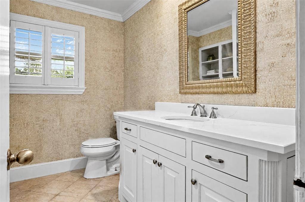 8629 Edgemere Road, #13, Dallas, TX 75225 White vanity with an integrated sink and countertop, textured wall covering, plantation shutters, and crown molding