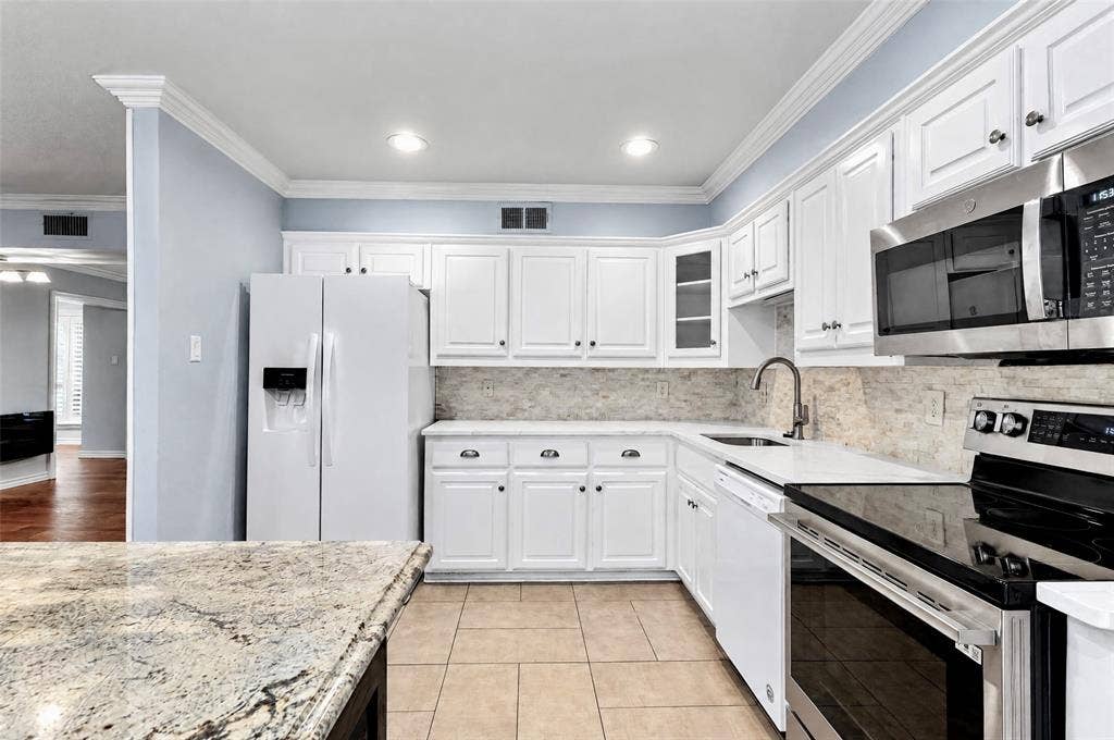 8629 Edgemere Road, #13, Dallas, TX 75225 Kitchen featuring white shaker-style cabinetry, stone-finish countertops, stainless steel appliances, tiled backsplash, and recessed lighting