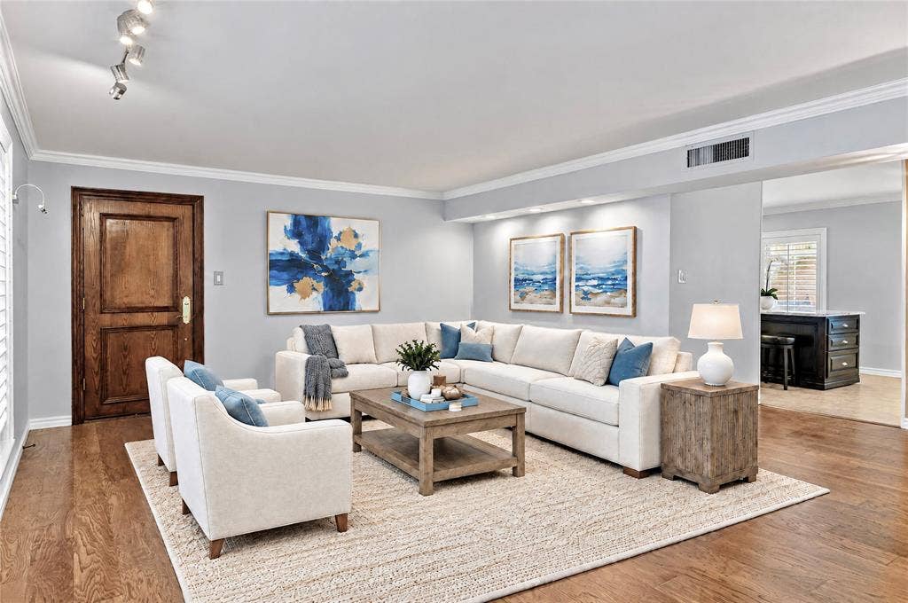 8629 Edgemere Road, #13, Dallas, TX 75225 Living area featuring wood-finish flooring, crown molding, a recessed wall niche with integrated lighting, and a multi-panel solid wood entry door