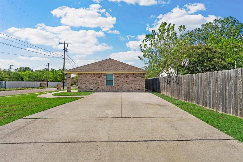 2125 Burnett Avenue, Waco, TX 76706 Unit B Brick exterior with a hipped roof, concrete driveway, and wood-fencing
