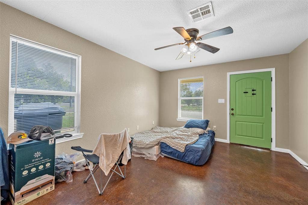 2125 Burnett Avenue, Waco, TX 76706 Unit B Interior space featuring stained concrete flooring, neutral wall paint, a multi-blade ceiling fan with integrated lighting, and a solid-core entry door with an integrated peep window