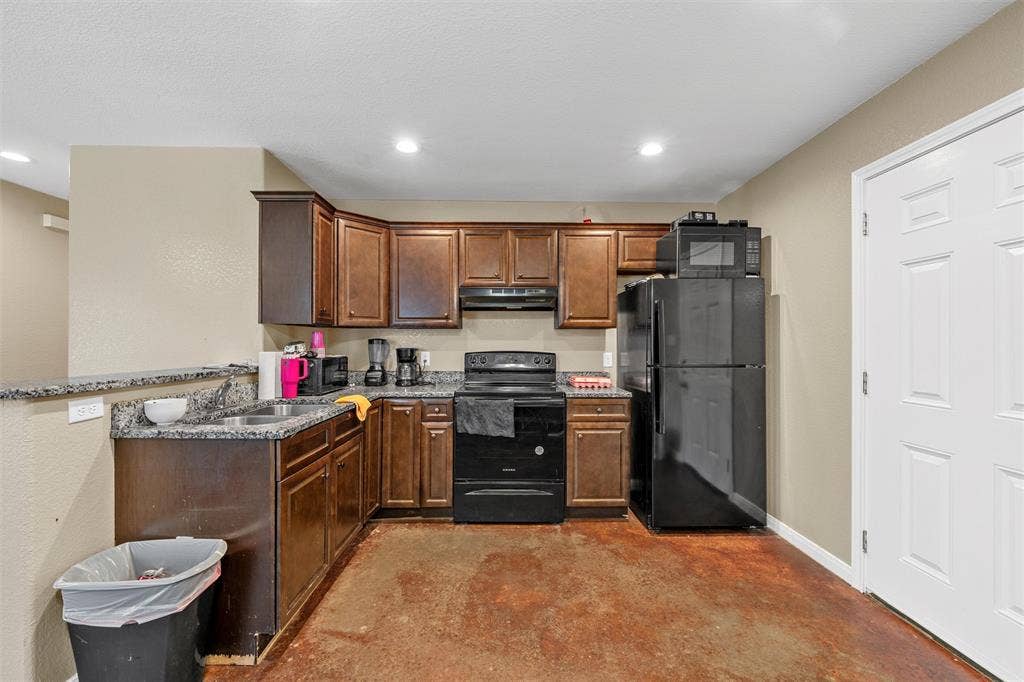 2125 Burnett Avenue, Waco, TX 76706 Unit B Kitchen featuring dark-toned wood cabinetry, stone-finish countertops, and recessed lighting