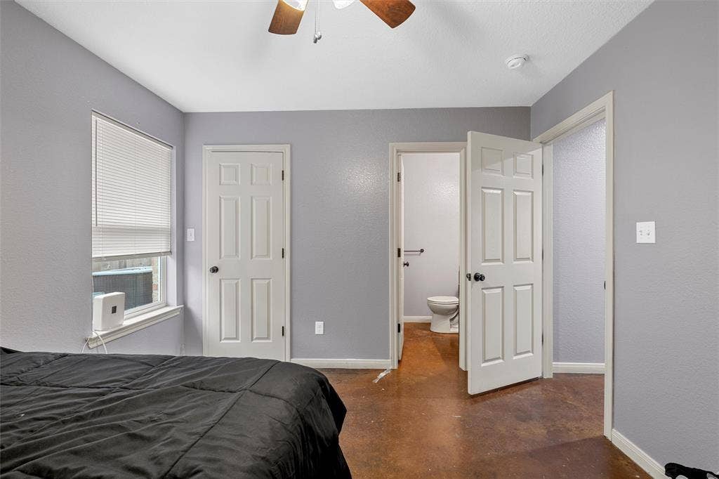 2125 Burnett Avenue, Waco, TX 76706 Unit A Stained concrete flooring, neutral grey wall paint, white six-panel interior doors, and a ceiling-mounted fan with light fixture