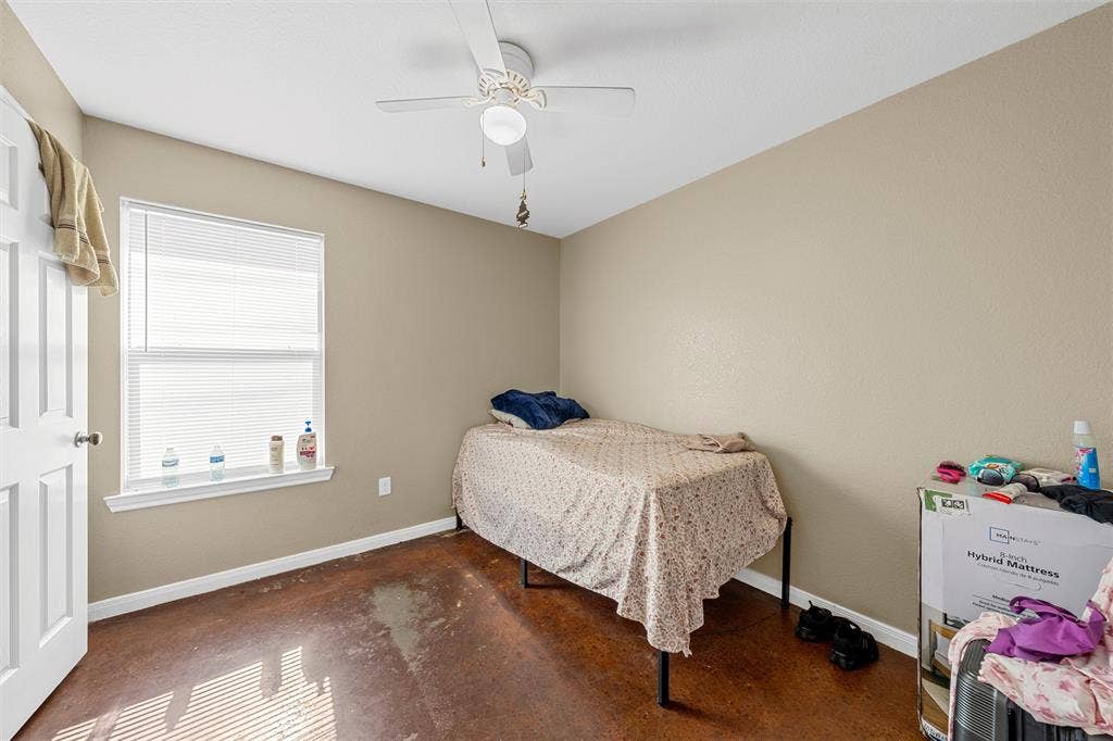 2125 Burnett Avenue, Waco, TX 76706 Unit B Room featuring stained concrete flooring, a white ceiling fan with integrated lighting, a single window with blinds, and a multi-panel interior door