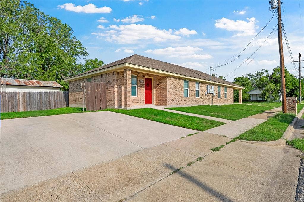 2125 Burnett Avenue, Waco, TX 76706 Unit A Single-story brick exterior featuring a hipped roof, concrete driveway, and wooden privacy fencing