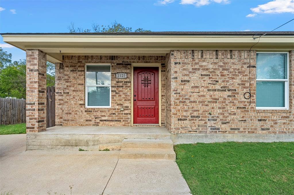 2125 Burnett Avenue, Waco, TX 76706 Unit A Brick exterior featuring a covered front porch, red-paneled entry door with decorative iron accents, and concrete walkway