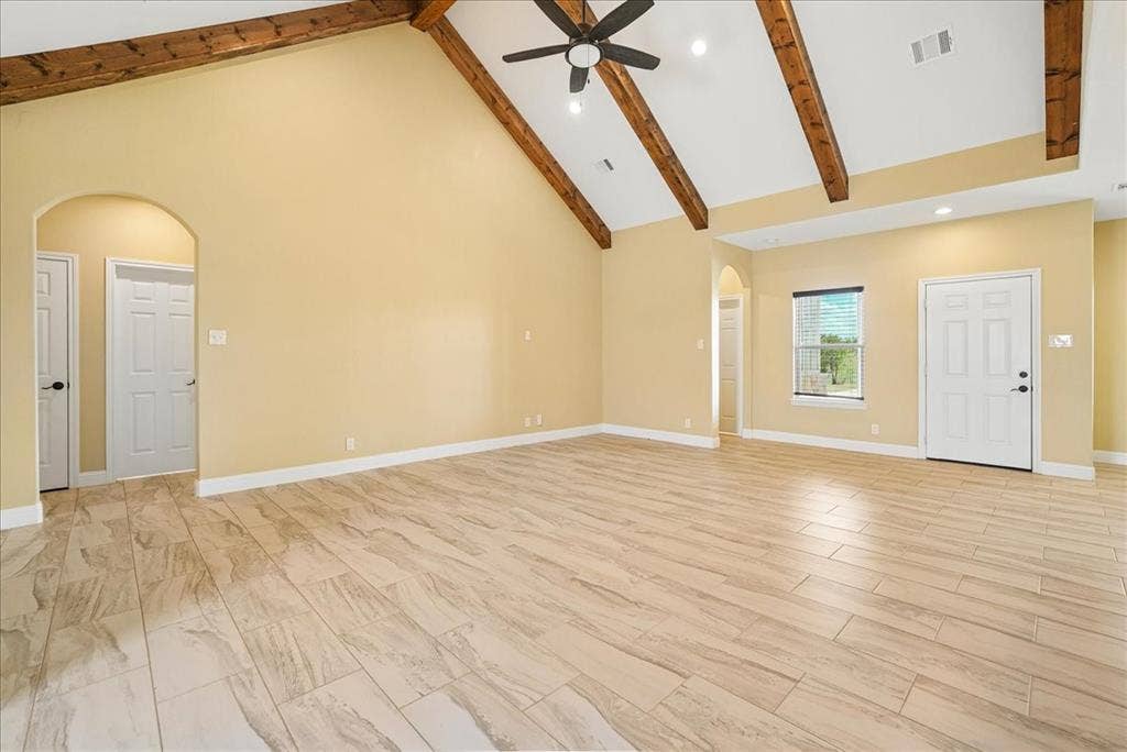 9060 Mitchell Bend Court, Granbury, TX 76048 Vaulted ceiling with exposed wood beams, neutral-tone tile flooring, arched doorways, and recessed lighting