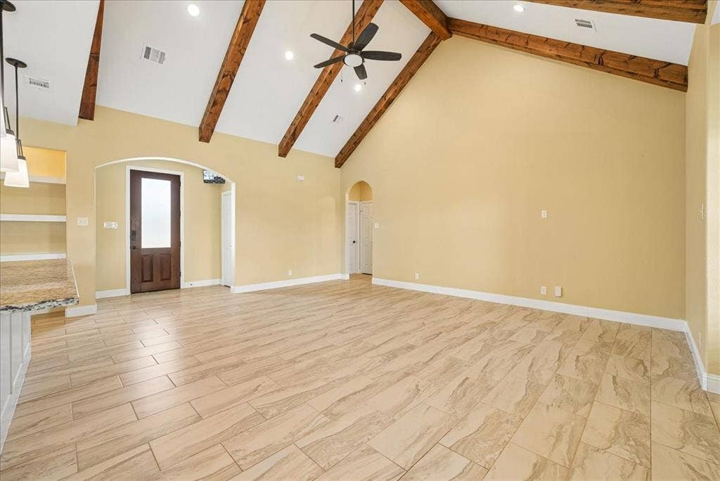 9060 Mitchell Bend Court, Granbury, TX 76048 Vaulted ceiling featuring exposed wood beams, tile flooring, arched doorways, recessed lighting, and a ceiling fan with integrated lighting