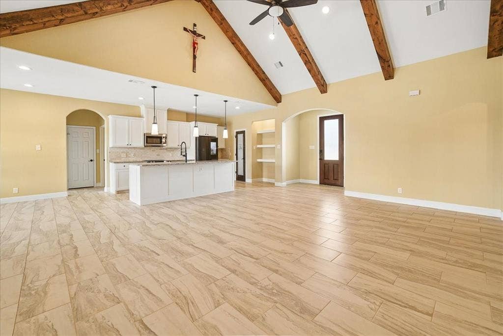 9060 Mitchell Bend Court, Granbury, TX 76048 Vaulted ceiling with exposed wood beams, wood-finish tile flooring, white cabinetry, kitchen island with stone countertop, and recessed lighting