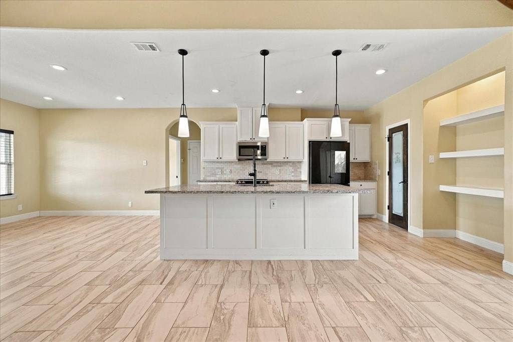 9060 Mitchell Bend Court, Granbury, TX 76048 Kitchen featuring a central island with stone countertop, white cabinetry, recessed lighting, trio of pendant lights, and wood-finish flooring